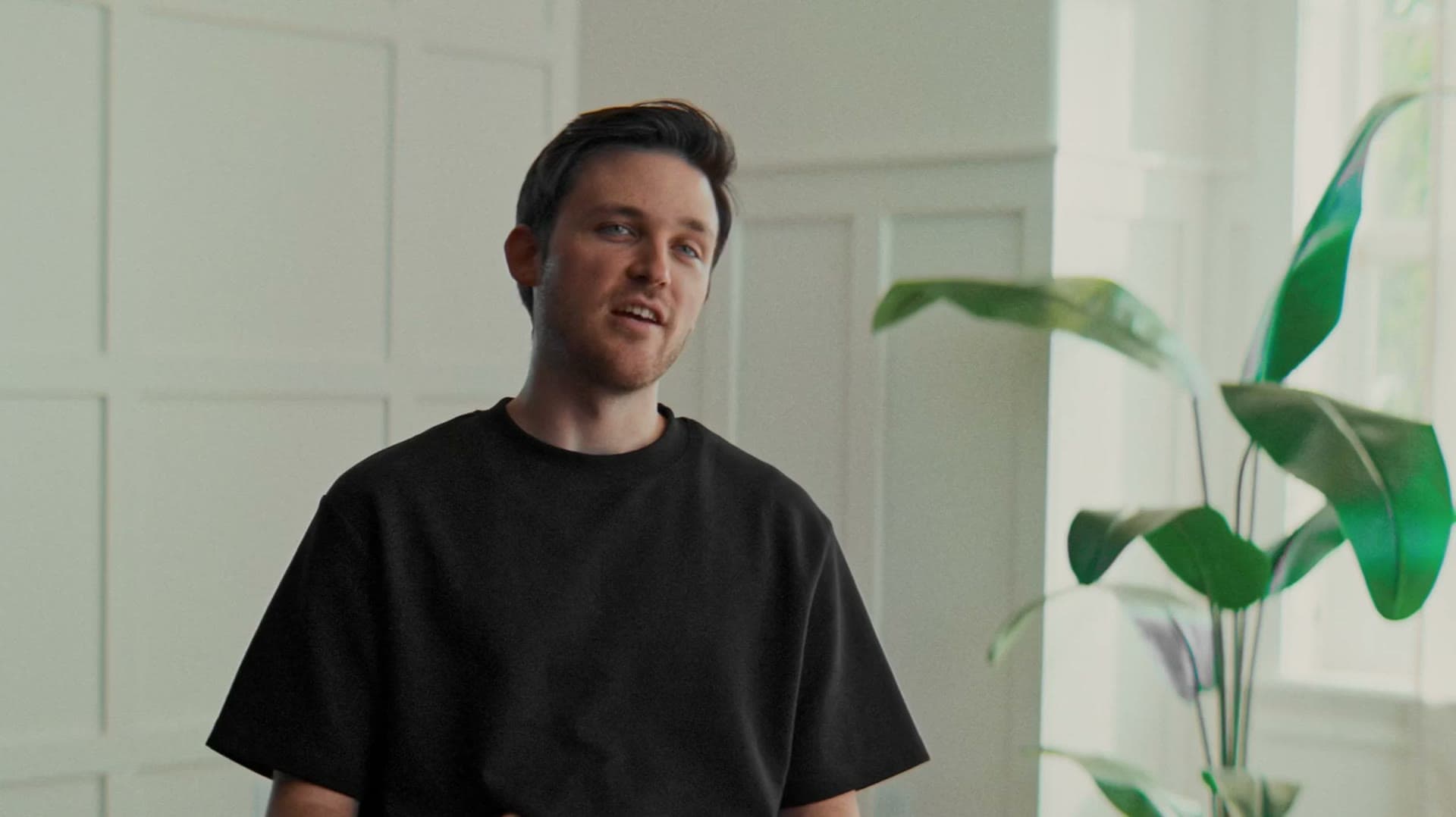 Chandler Rogers, Relay's founder, seated in a bright room beside a tall plant — a still from the founder story film
