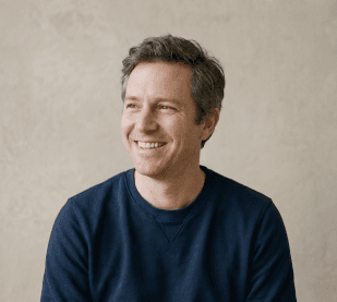 A smiling man in a navy sweater